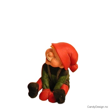 Stor sittende nisse med hånden mellom bena