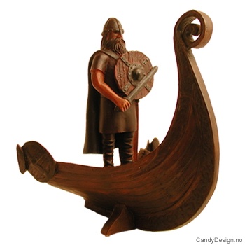 Viking figur stående i stavnen på vikingskip med skjold og vikingsverd